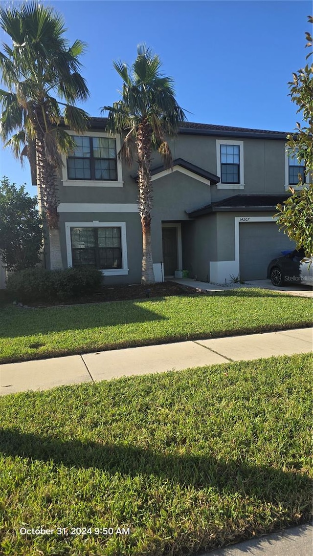 14207 Alistar Manor Dr, Wimauma, FL 33598 - traditional-style home featuring stucco siding, a garage, a front lawn, and concrete driveway