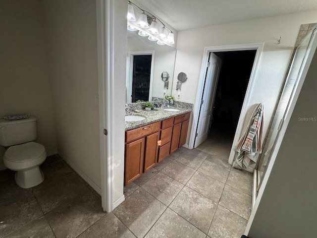 bathroom with tile patterned flooring, vanity, and toilet