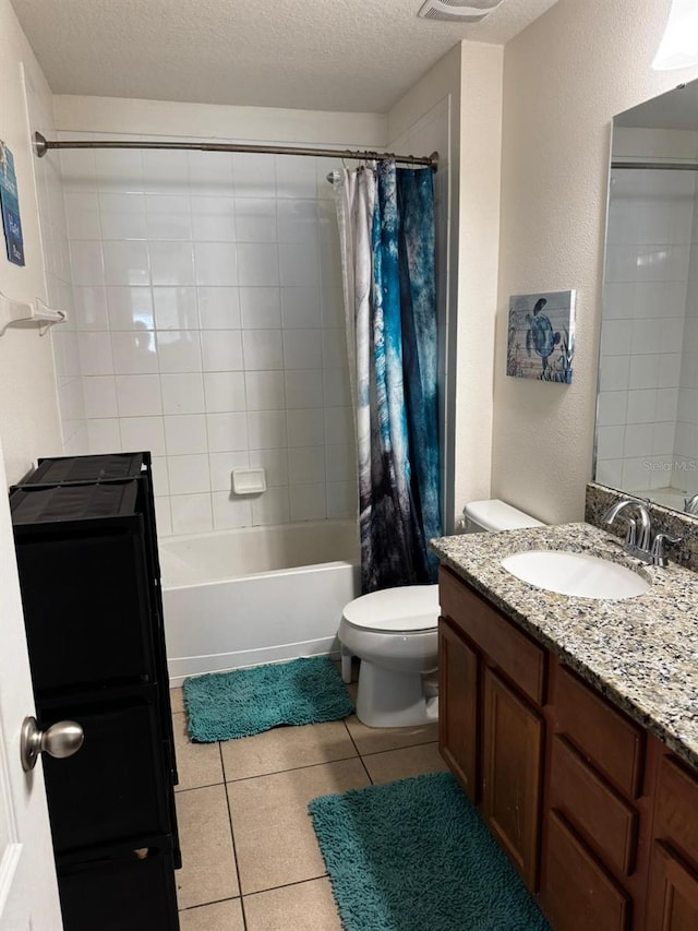 full bathroom with shower / bath combo, tile patterned floors, a textured ceiling, toilet, and vanity