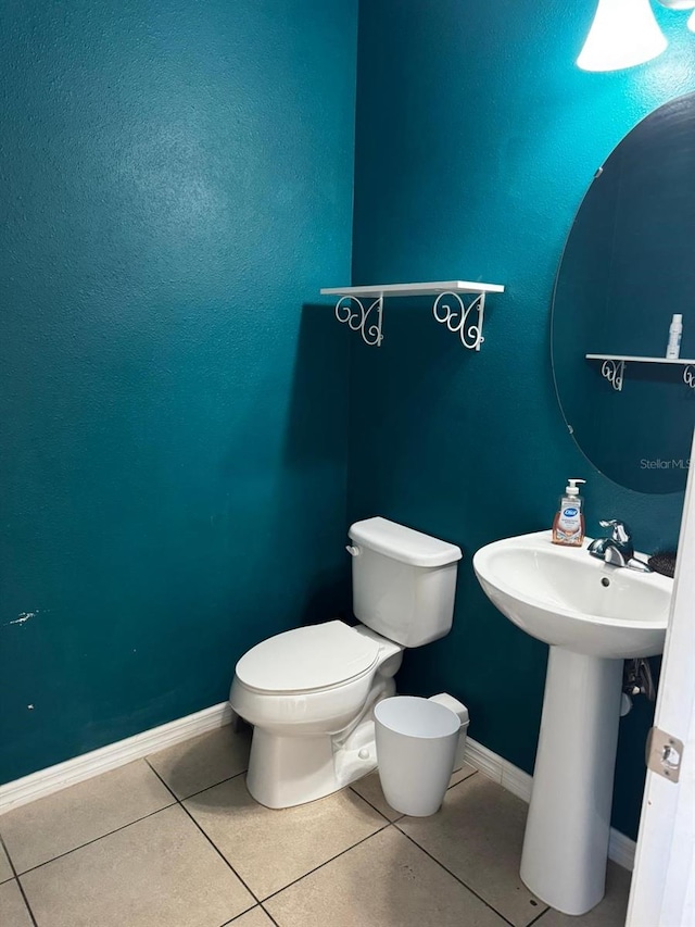 14207 Alistar Manor Dr, Wimauma, FL 33598 - half bathroom featuring toilet, baseboards, tile patterned floors, and a sink