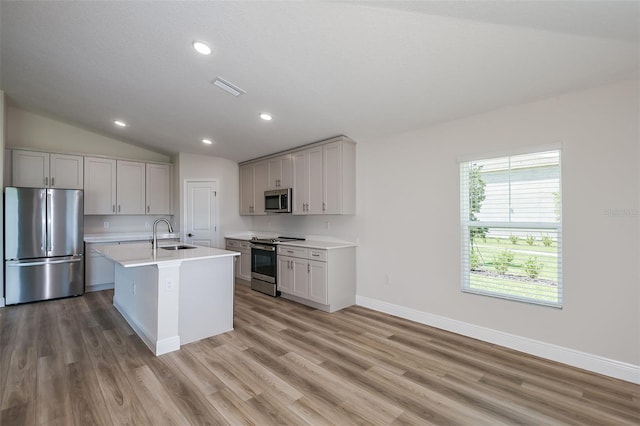 kitchen featuring a sink, visible vents, vaulted ceiling, light countertops, and appliances with stainless steel finishes