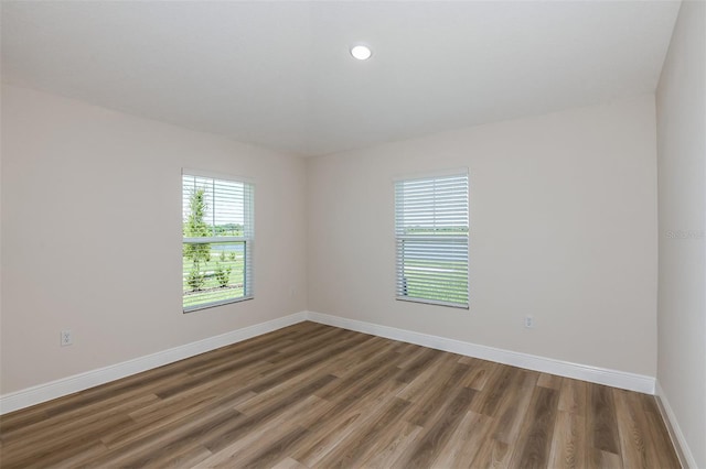 unfurnished room with baseboards and wood finished floors