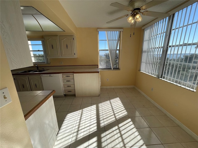 kitchen with dishwasher, sink, tile counters, and light tile patterned flooring