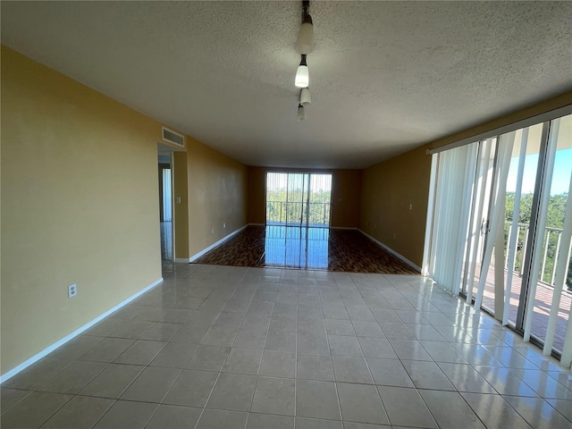 empty room with light tile patterned floors and a textured ceiling