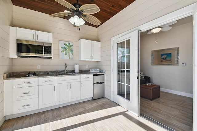 kitchen with wood ceiling, white cabinetry, appliances with stainless steel finishes, and light hardwood / wood-style flooring