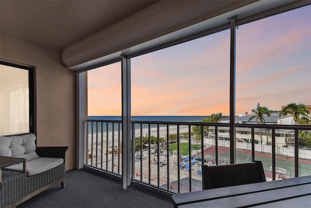 sunroom / solarium featuring a water view