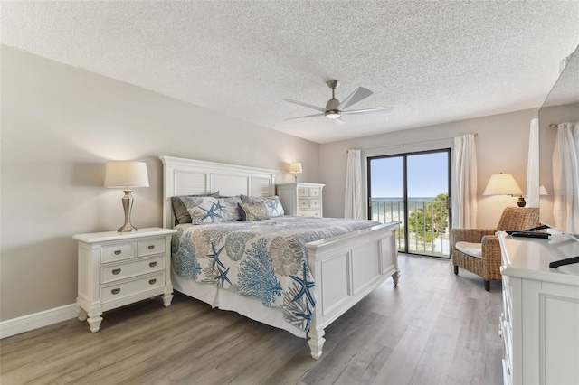 bedroom featuring hardwood / wood-style floors, ceiling fan, access to exterior, and a textured ceiling