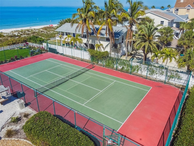 view of tennis court with a beach view, basketball court, and a water view