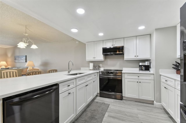 kitchen featuring white cabinets, sink, appliances with stainless steel finishes, kitchen peninsula, and a chandelier