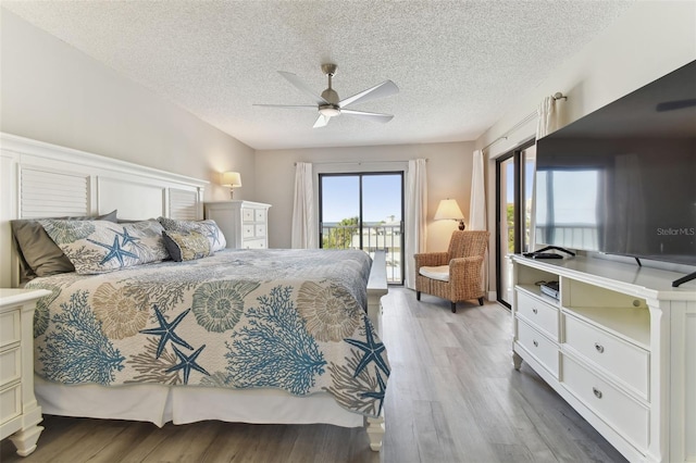 bedroom featuring hardwood / wood-style floors, ceiling fan, access to exterior, and a textured ceiling