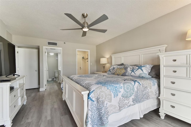 bedroom with hardwood / wood-style floors, ceiling fan, a textured ceiling, and ensuite bath