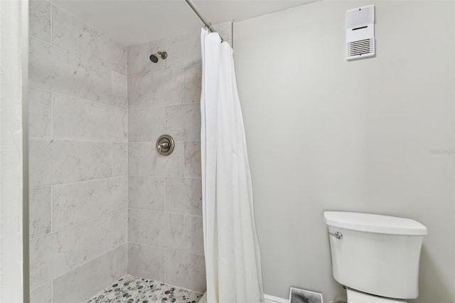 bathroom with a shower with curtain and toilet