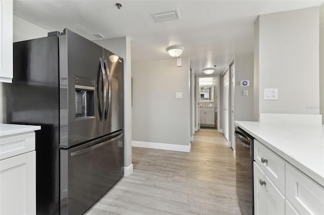 kitchen featuring white cabinets, light wood-type flooring, and appliances with stainless steel finishes