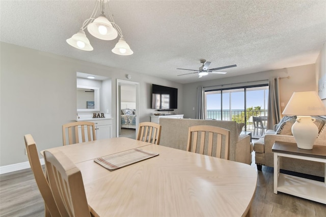 dining space with ceiling fan, a textured ceiling, and hardwood / wood-style flooring