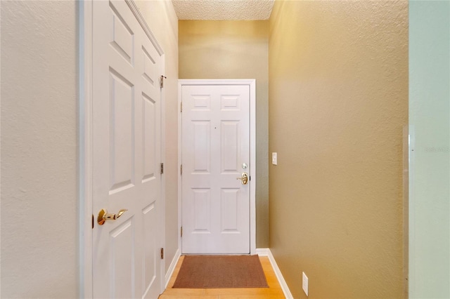 entryway with wood-type flooring and a textured ceiling