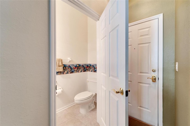 bathroom featuring tile patterned floors, toilet, and ornamental molding