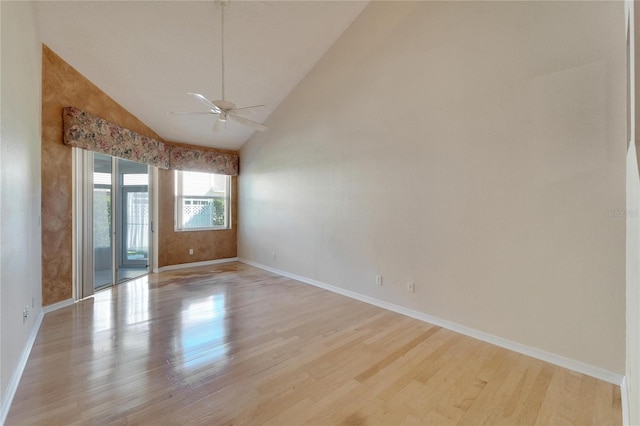 empty room with ceiling fan, light hardwood / wood-style flooring, and high vaulted ceiling