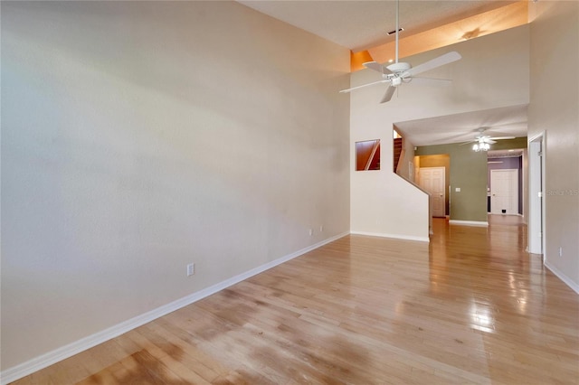 spare room featuring high vaulted ceiling and light hardwood / wood-style floors