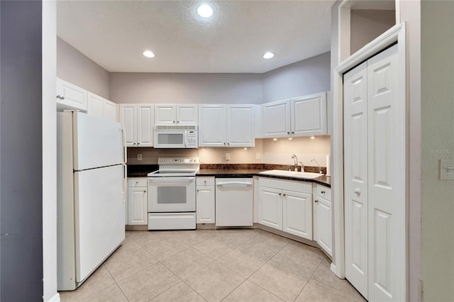 kitchen featuring white cabinets, a textured ceiling, white appliances, and sink