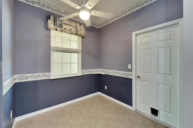 tiled empty room featuring ceiling fan