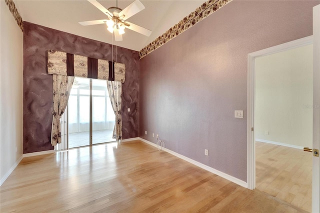 unfurnished room featuring ceiling fan, vaulted ceiling, and light wood-type flooring