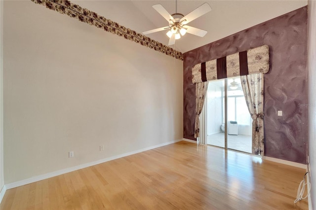 empty room featuring hardwood / wood-style floors, vaulted ceiling, and ceiling fan