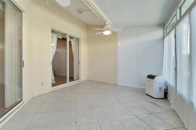 unfurnished sunroom with ceiling fan