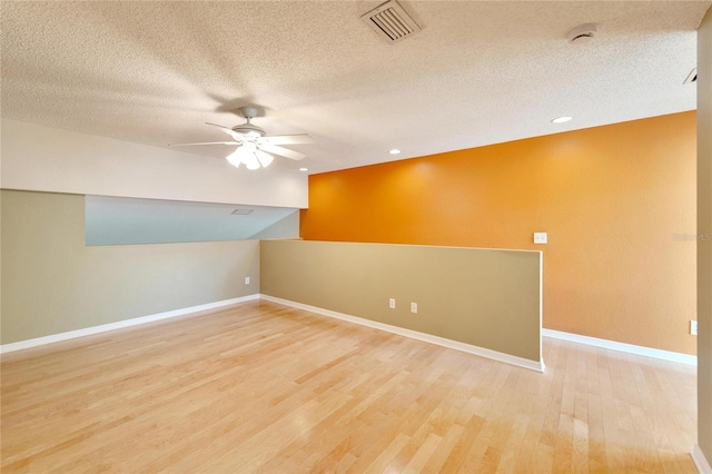 spare room with hardwood / wood-style floors, ceiling fan, and a textured ceiling