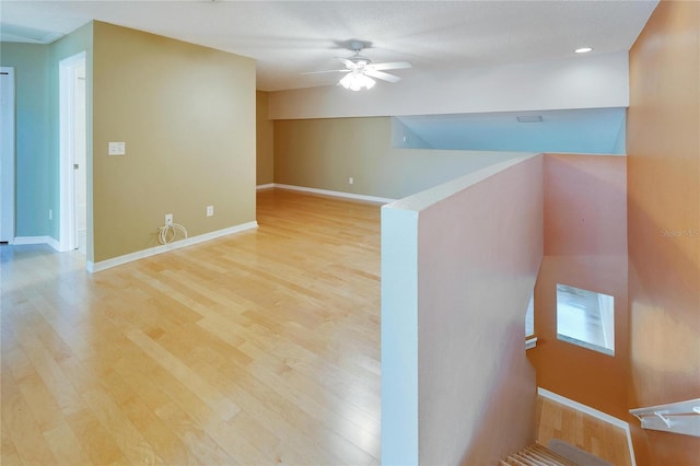 unfurnished room with ceiling fan and light wood-type flooring