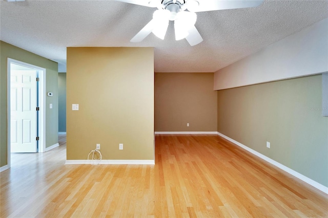 empty room with ceiling fan, a textured ceiling, and light hardwood / wood-style flooring