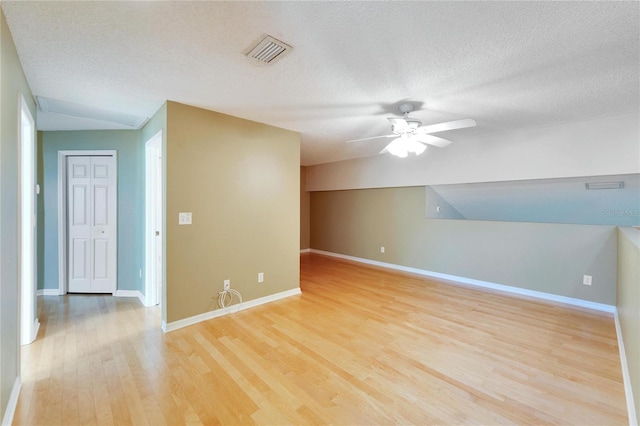 bonus room featuring ceiling fan, light wood-type flooring, and a textured ceiling