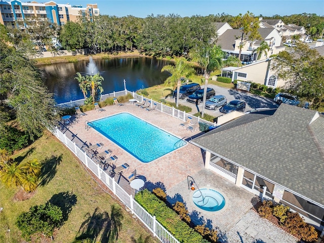 view of swimming pool featuring a patio and a water view