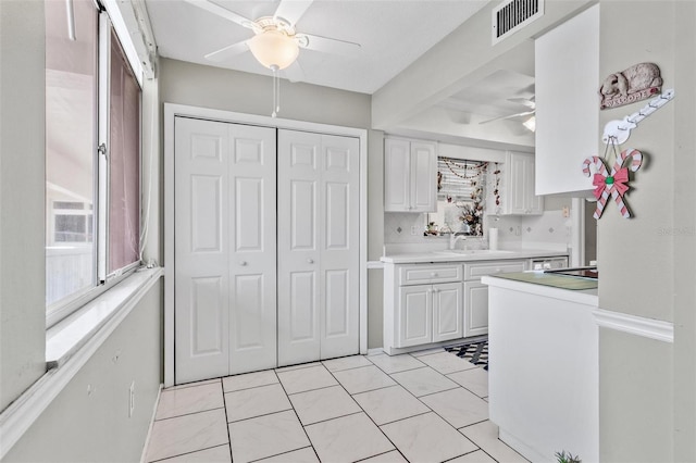 2650 Pearce Dr Unit 403, Clearwater, FL 33764 - kitchen featuring ceiling fan, white cabinets, light countertops, and a sink
