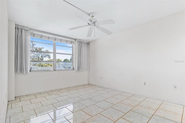 spare room with ceiling fan and light tile patterned floors