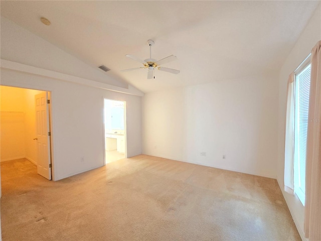 carpeted empty room with vaulted ceiling and ceiling fan