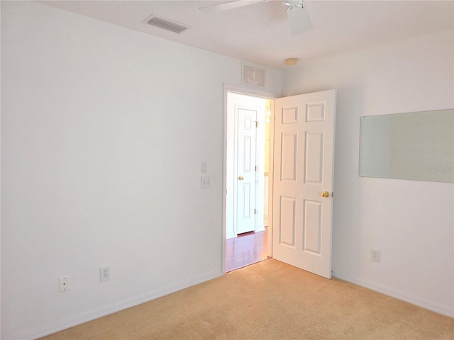 carpeted spare room with ceiling fan