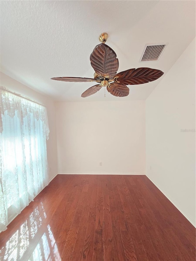 spare room featuring hardwood / wood-style flooring, ceiling fan, and a textured ceiling