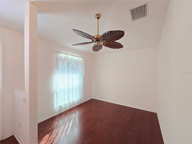 unfurnished room with ceiling fan, dark hardwood / wood-style floors, and a textured ceiling