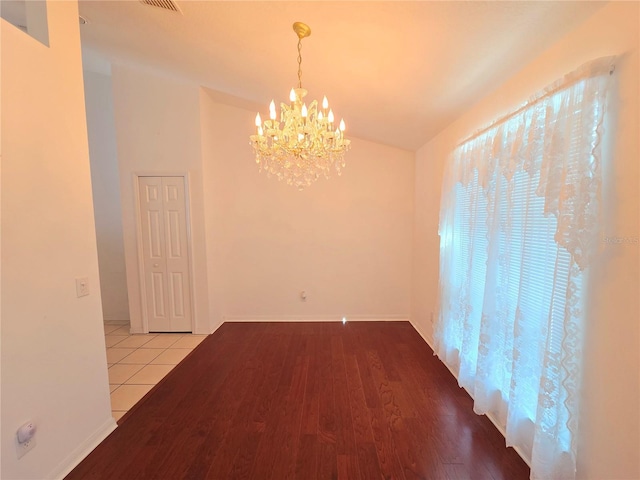 unfurnished room with light hardwood / wood-style flooring and an inviting chandelier