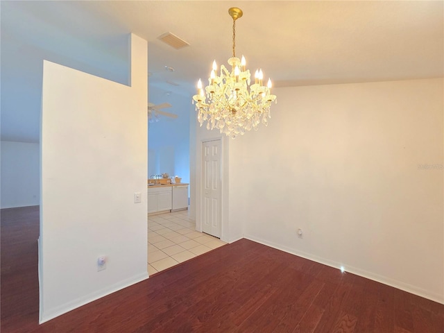 spare room with light wood-type flooring and an inviting chandelier