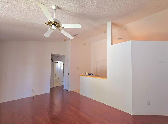 spare room featuring ceiling fan, lofted ceiling, wood-type flooring, and a textured ceiling