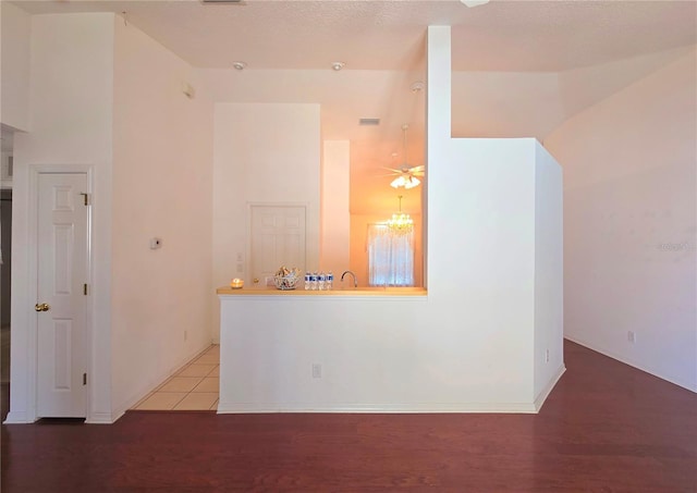 empty room featuring a textured ceiling, hardwood / wood-style floors, and a towering ceiling