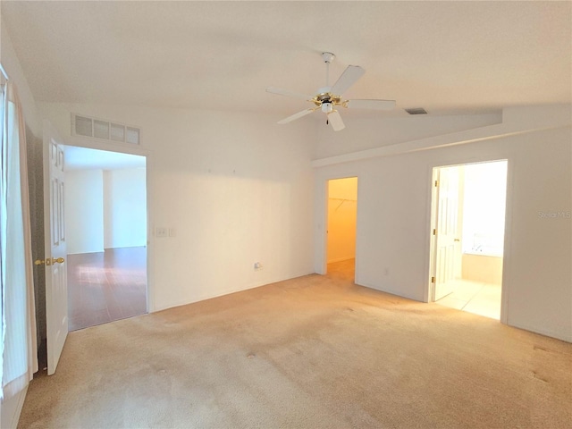 carpeted empty room featuring vaulted ceiling and ceiling fan