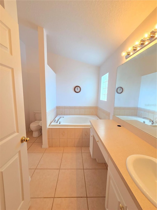 bathroom featuring toilet, tiled tub, a textured ceiling, tile patterned floors, and vanity