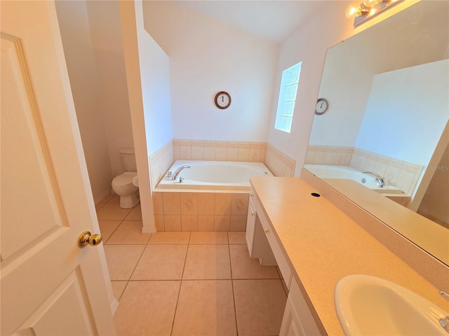 bathroom featuring tiled bath, tile patterned floors, vanity, and toilet