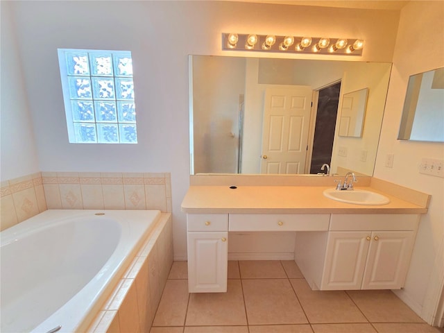 bathroom featuring tile patterned floors, vanity, and tiled tub