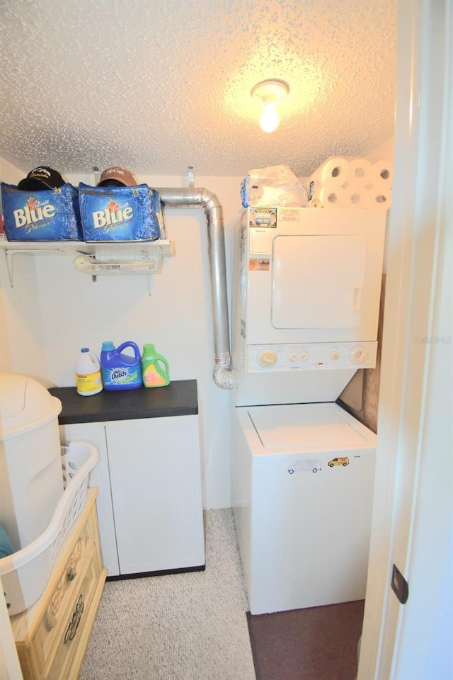 laundry area with a textured ceiling, stacked washing maching and dryer, and light colored carpet