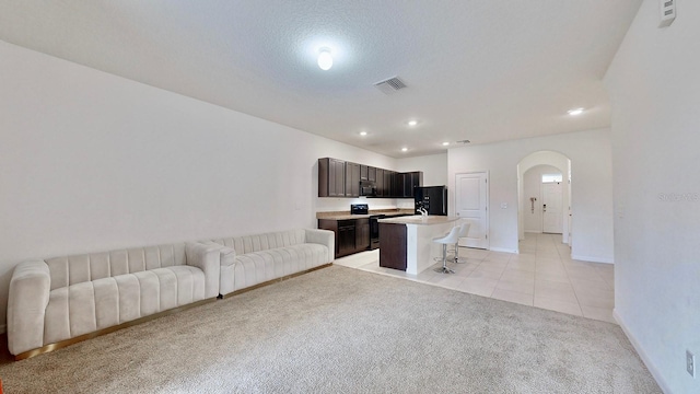 living room with light tile patterned flooring and a textured ceiling