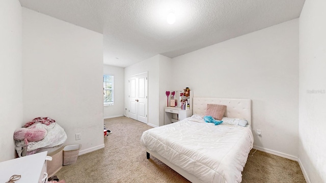 bedroom with light colored carpet and a textured ceiling