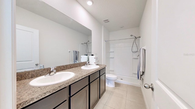 bathroom featuring vanity, tile patterned flooring, a shower, and toilet